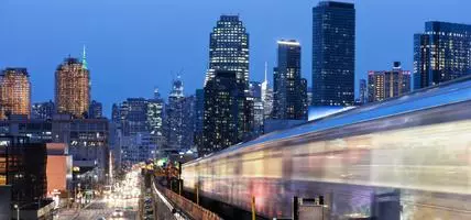 city at night with moving trains and headlights