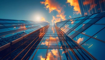 Skyscraper glass facades on a bright sunny day with sunbeams in the blue sky. 