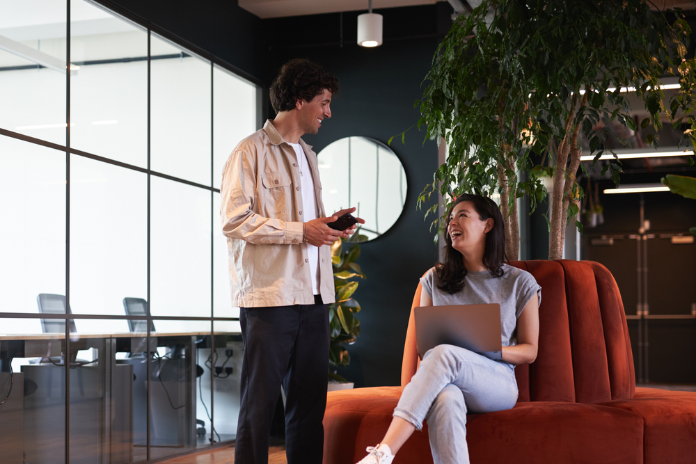 Young couple in work space for start up business have meeting in seating area of open plan office