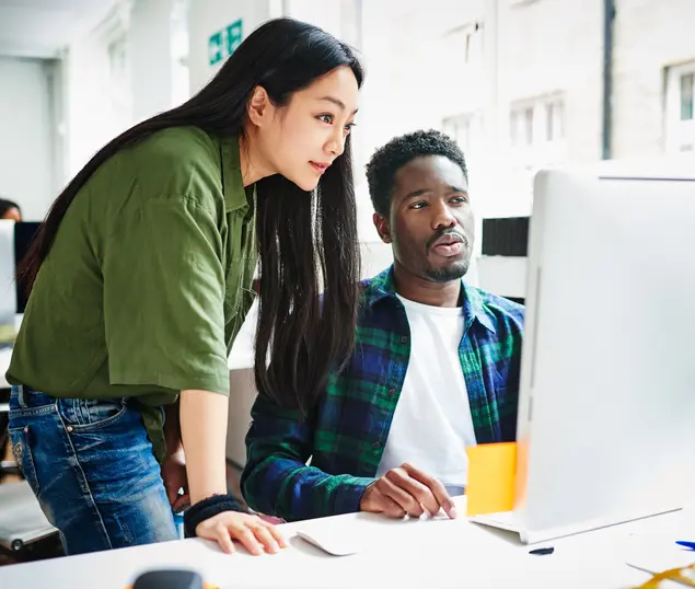 Colleagues in office looking at a computer screen