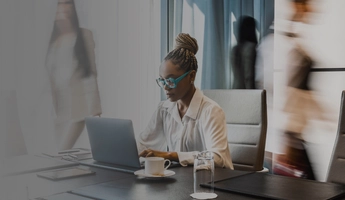 Woman with blue glasses working at laptop
