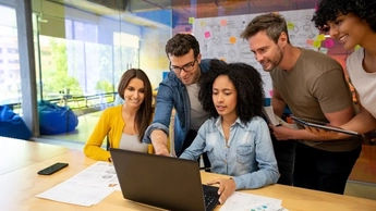 colleagues gathered around a laptop