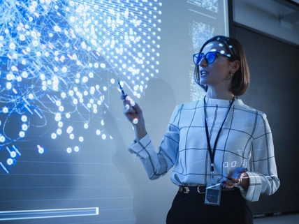 Young University Professor Explaining a Web Development Project to a Group of Students in a Dark Auditorium. Female Teacher Showing a Back-End Programmers Code on a Big Projector Screen, [