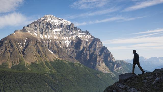 man standing on edge of mountain