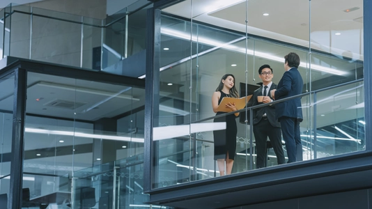 people meeting outside of glass office windows