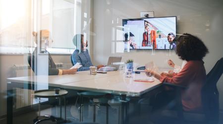 Group of young business people discussing with colleagues on video conference on meeting