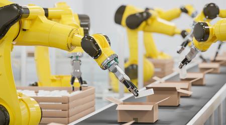 Robots at a conveyor belt packing items into cardboard packages
