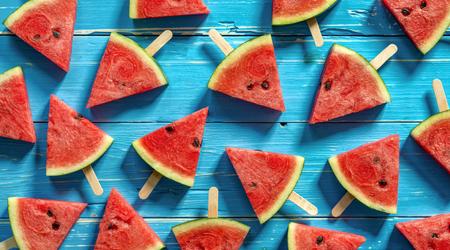 Watermelon slice popsicles on a blue rustic wood background