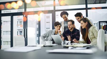 Cropped shot of a group of businesspeople working together on a laptop in a modern office