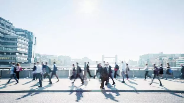 people walking on a bridge in sunlight